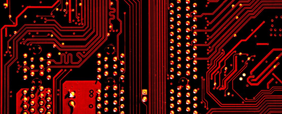 Image of computer circuitry in a harsh red tint.